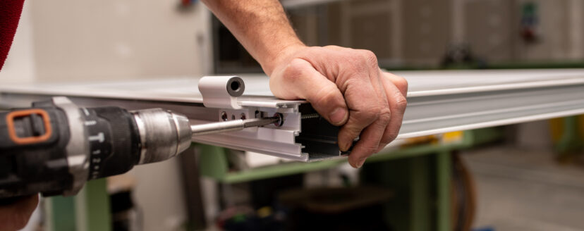 A male with a red shirt making a window with industrial tools