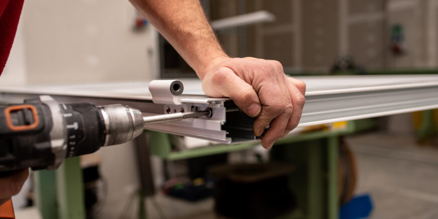 A male with a red shirt making a window with industrial tools