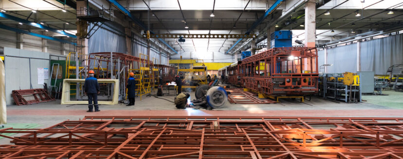 One working day of modern automatic bus trolleybus car production with unfinished cars workers in protective uniform in factory background automobile assembly line welding arm